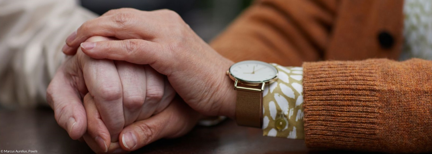 Zwei Menschen halten sich an den Händen