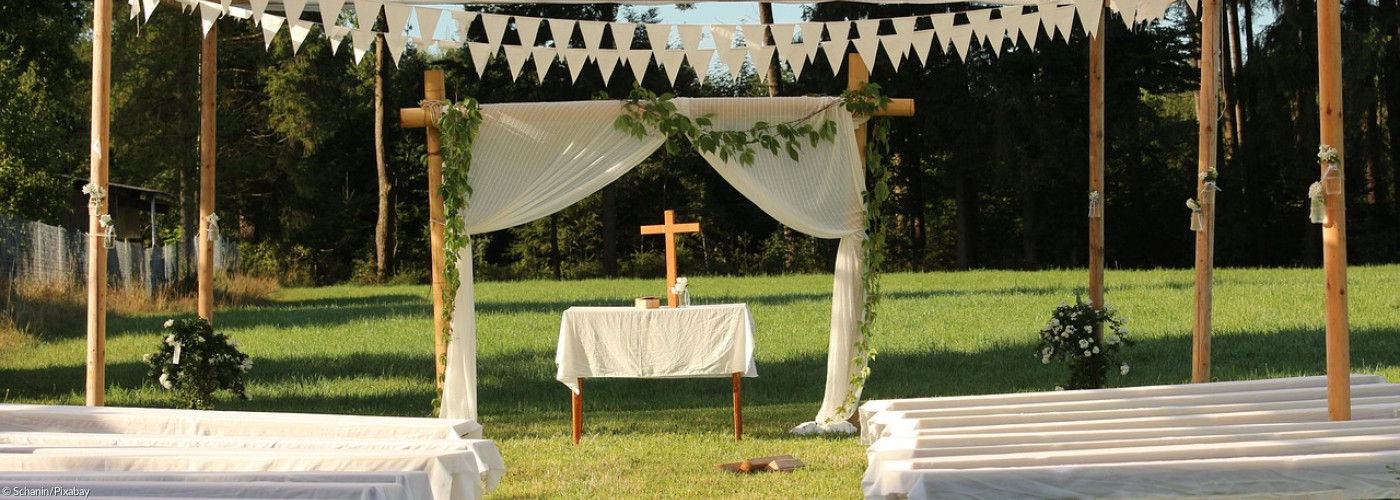 Hochzeitslocation mit Bänken und Kreuz