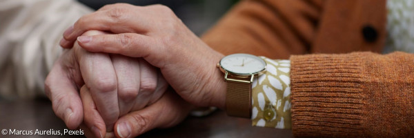 Zwei Menschen halten sich an den Händen