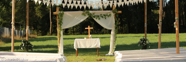 Hochzeitslocation mit Bänken und Kreuz