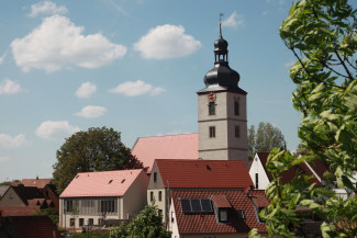 Zu sehen ist vorne links das Dekanatsgebäude, rechts vorne das Pfarrhaus und dahinter die Kirche St. Matthäus in Markt Einersheim